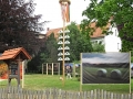 Eingang zum Garten des Ladencafés mit Maibaum
